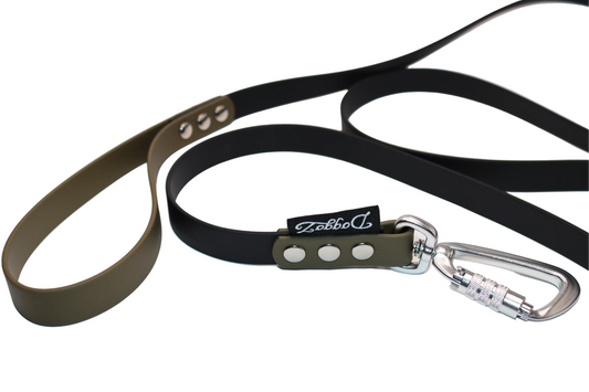 A black BioThane dog leash with an olive green handle and connector, featuring a silver locking carabiner, heavy-duty silver rivets, and the DoggoZ brand labels